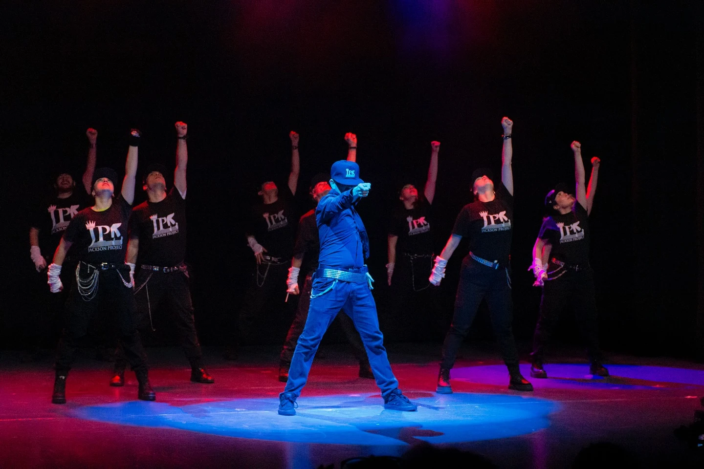 Un bailarín de traje azul encabeza la coreografía del elenco